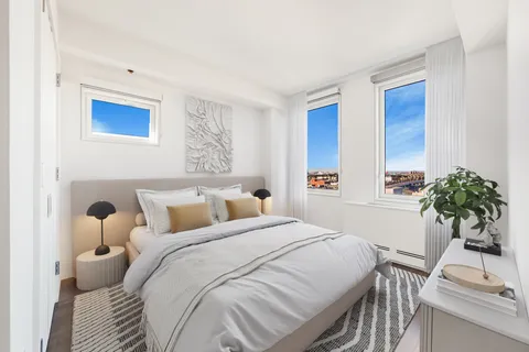a bedroom with a bed and a potted plant