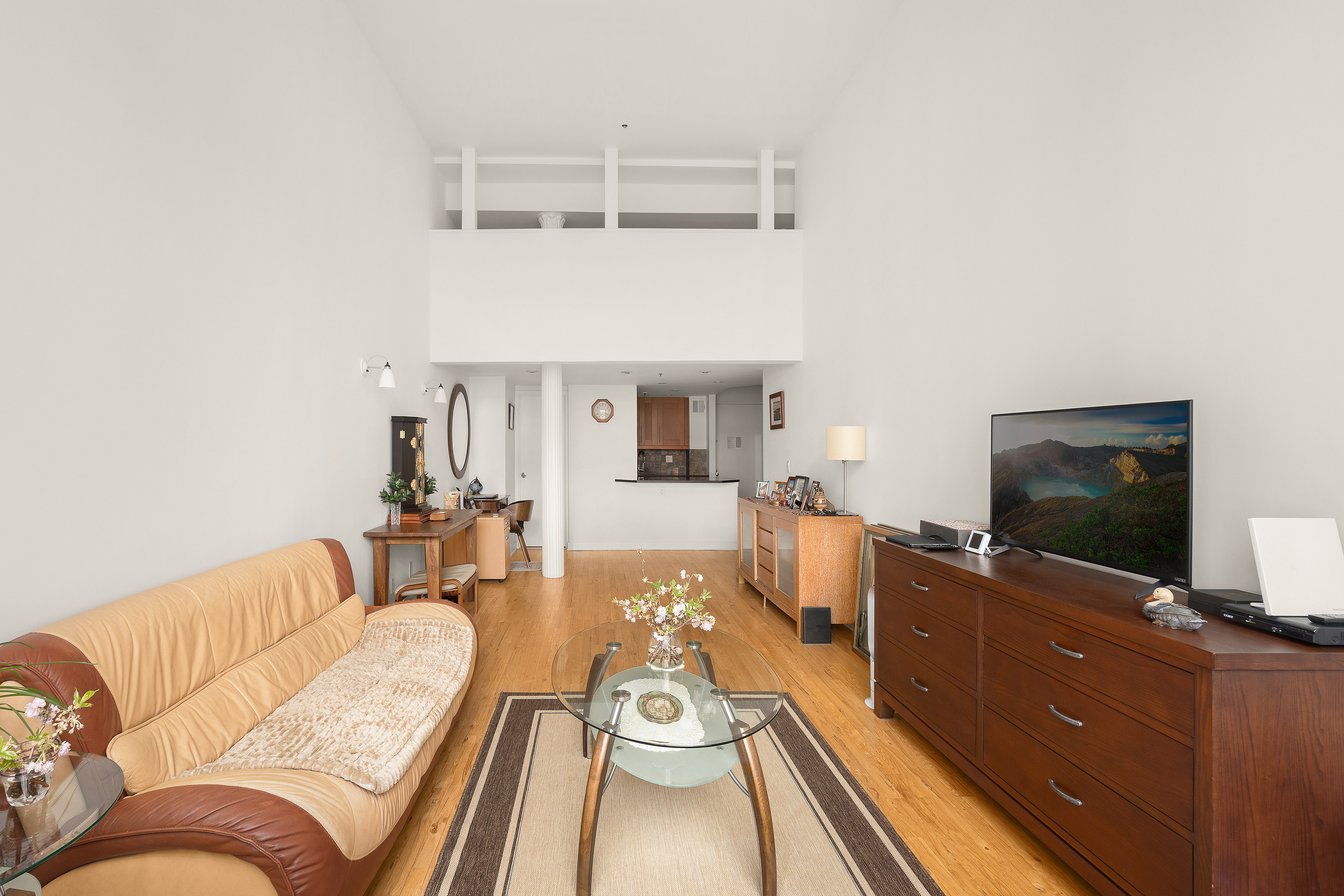 77 Bleecker Street, Unit 618 Manhattan, NY 10012 - Photo 2 of 6 a living room with furniture and a flat screen tv