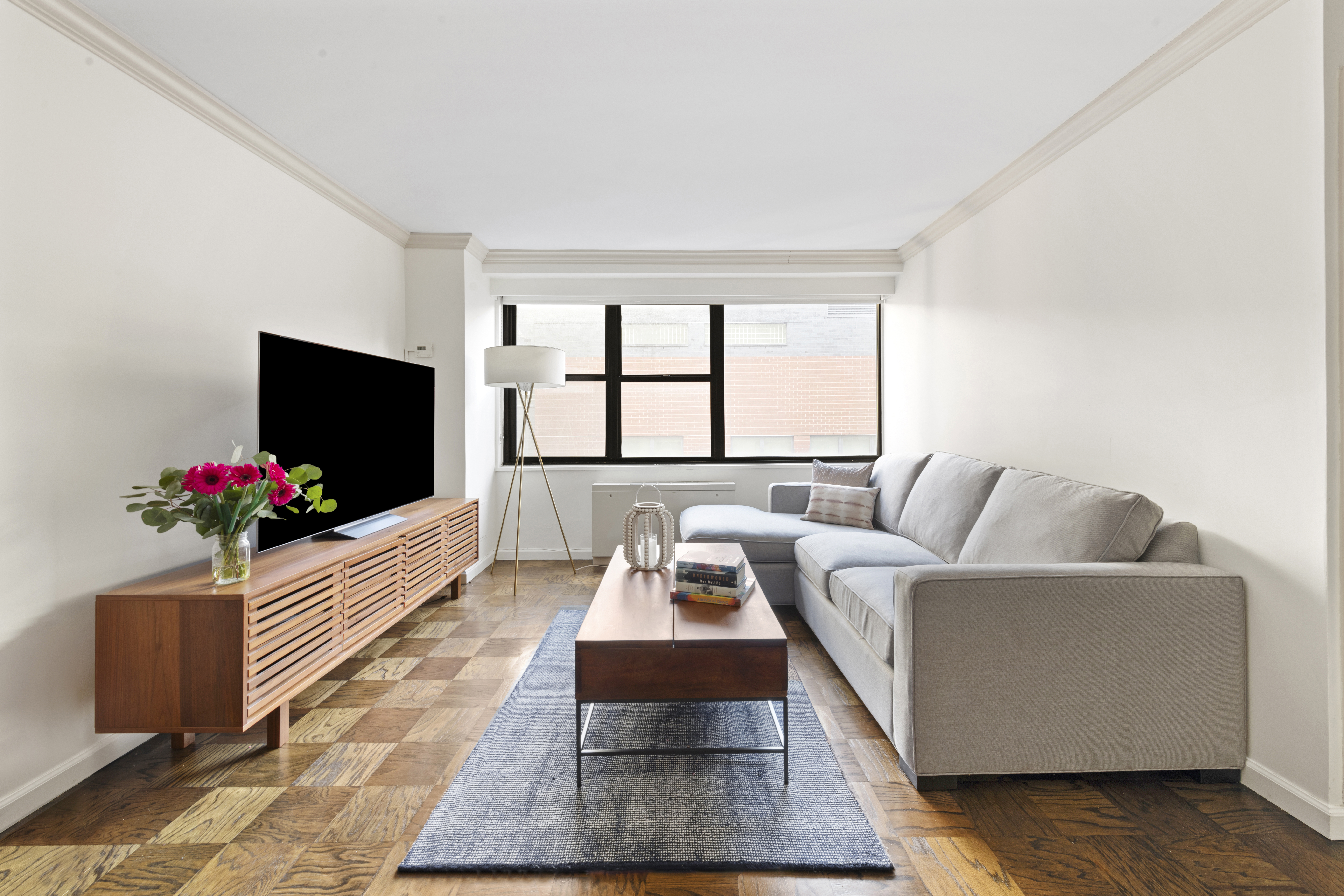 7 East 14th Street, Unit 1229 Manhattan, NY 10003 - Photo 3 of 9 a living room with furniture windows and a flat screen tv