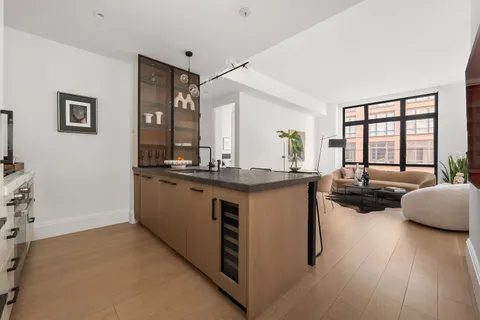 a large living room with stainless steel appliances kitchen island granite countertop wooden floor and a large window