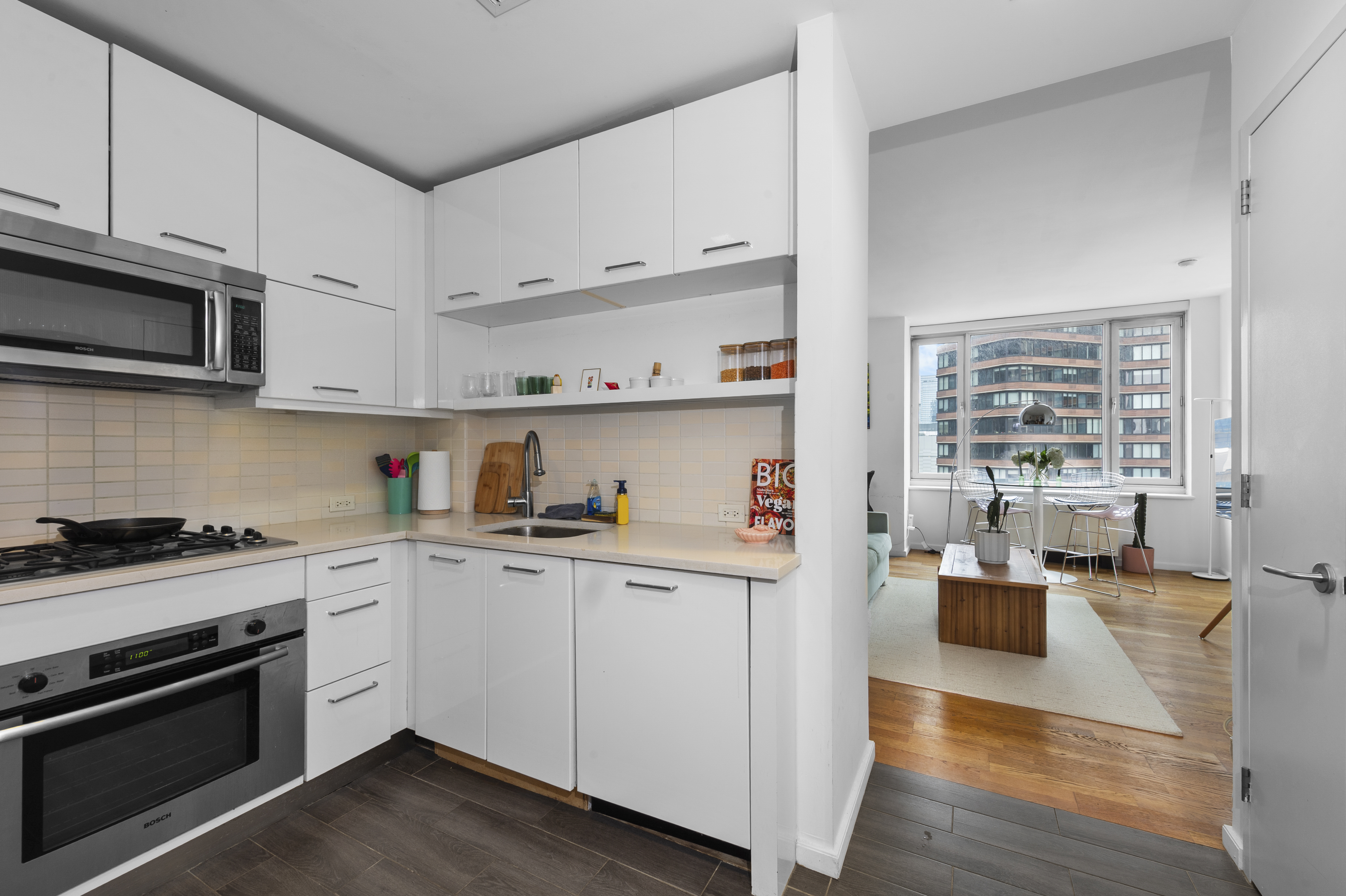635 West 42nd Street, Unit 14K Manhattan, NY 10036 - Photo 13 of 19 a kitchen with stainless steel appliances granite countertop a stove and white cabinets