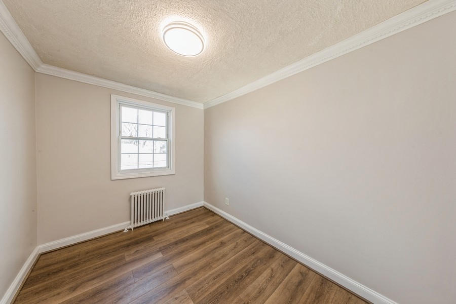 224-46 Horace Harding Expressway, Unit 630 Queens, NY 11364 - Photo 10 of 29 an empty room with wooden floor and windows