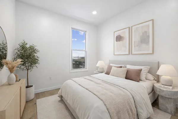 a bedroom with a bed and a potted plant