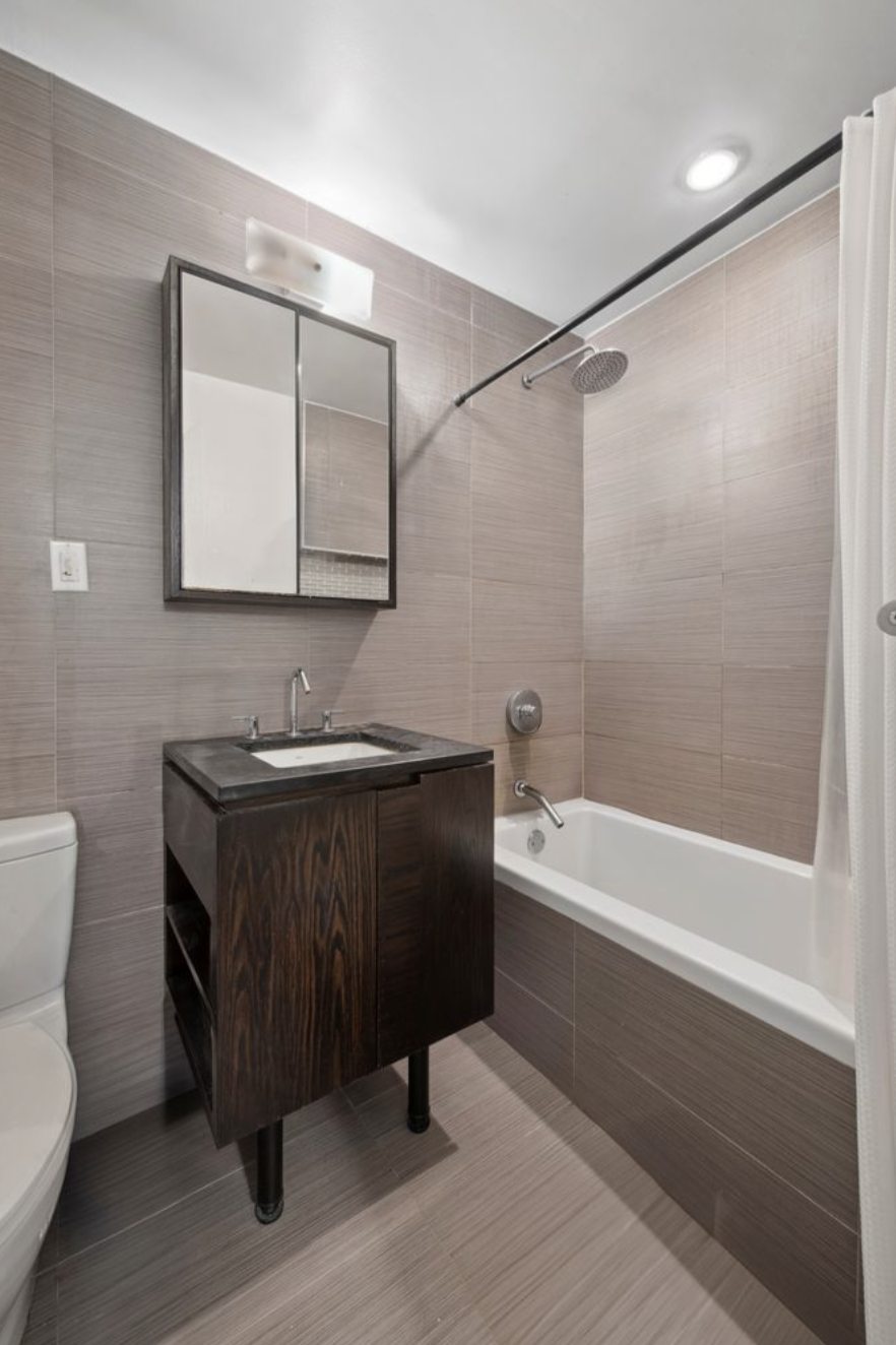 139 Skillman Avenue, Unit 9AB Brooklyn, NY 11211 - Photo 9 of 19 a bathroom with a bathtub a sink and a toilet