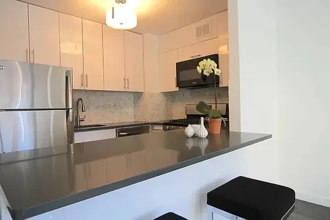 a kitchen with a refrigerator and a stove top oven