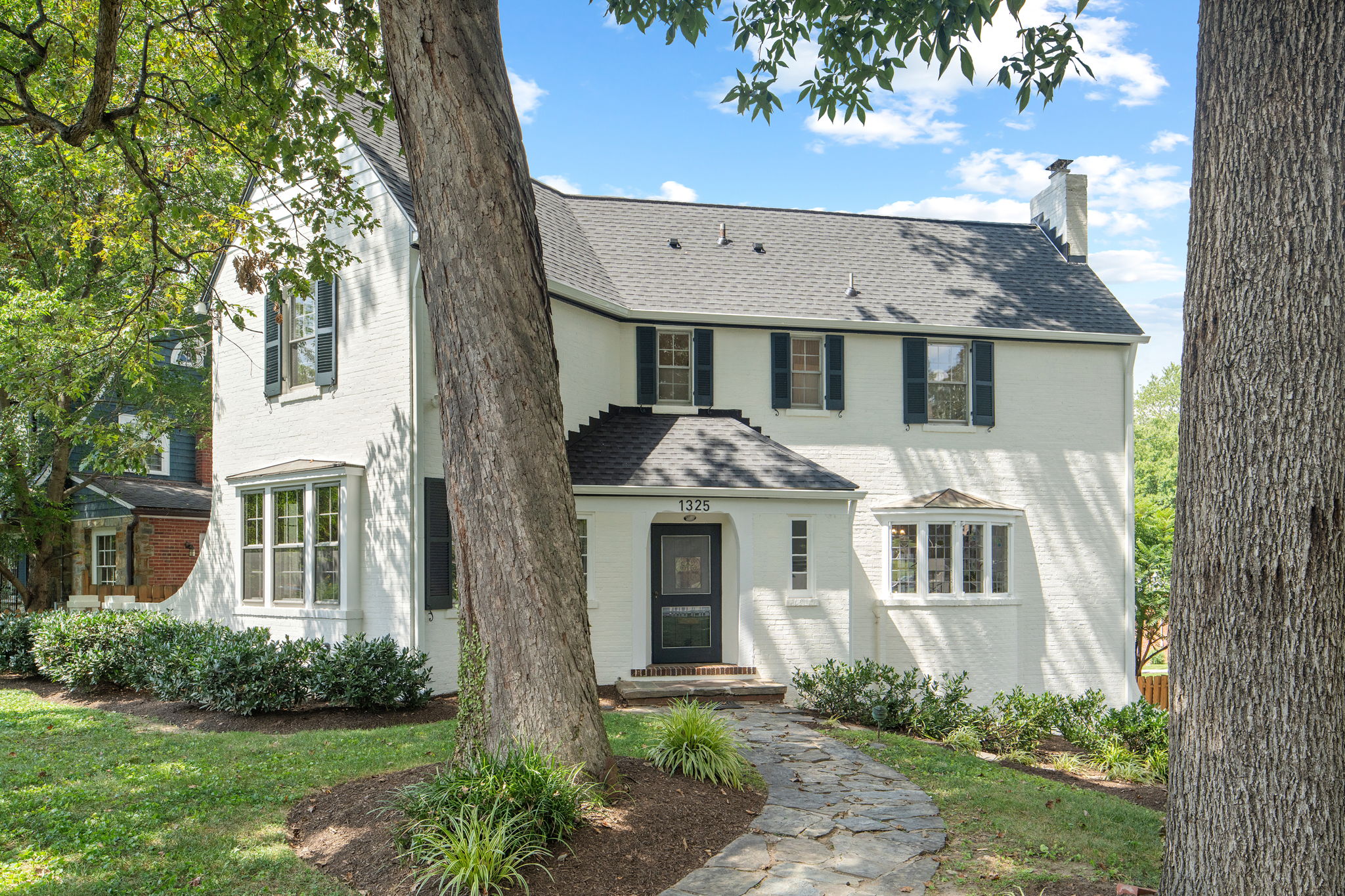 a front view of a house with a garden