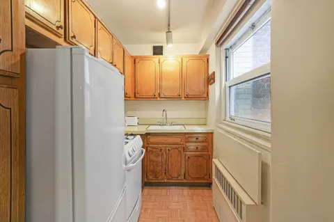 a kitchen with a sink a stove cabinets and a refrigerator