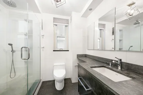 a bathroom with a granite countertop sink toilet and shower
