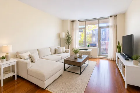 a living room with furniture wooden floor and a flat screen tv