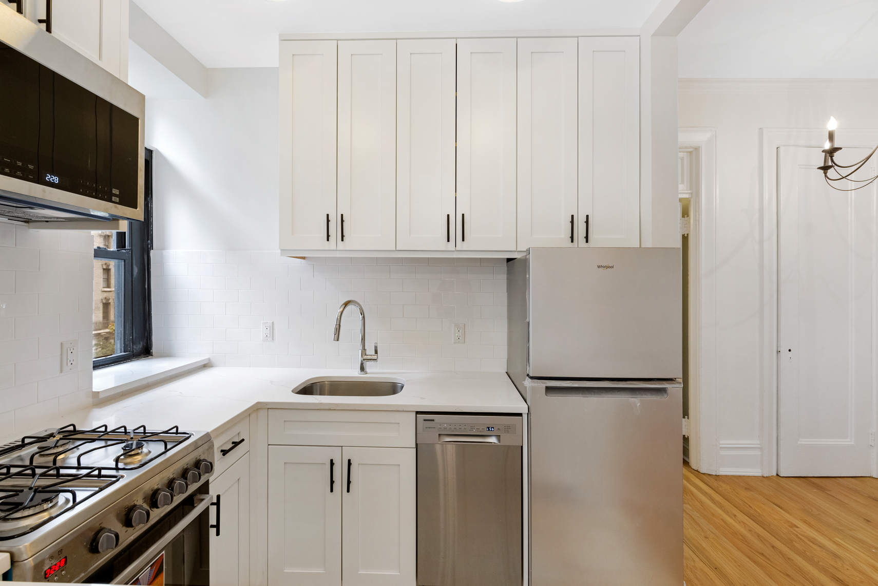 504-510 West 110th Street, Unit 5D Manhattan, NY 10025 - Photo 3 of 7 a kitchen with stainless steel appliances granite countertop a refrigerator sink and white cabinets
