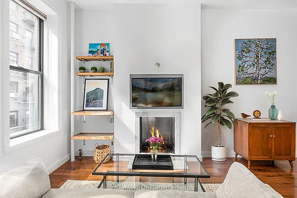 13 Downing Street, Unit 8 Manhattan, NY 10014 - Photo 2 of 10 a living room with furniture a flat screen tv and a fireplace