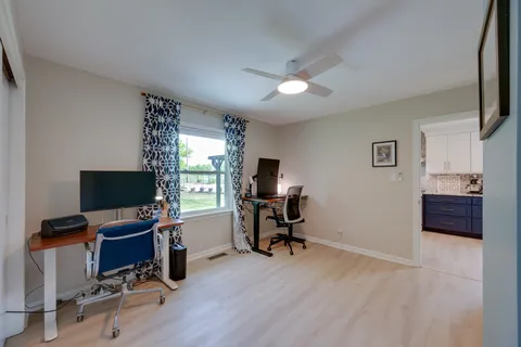 a view of a livingroom with workspace and a window