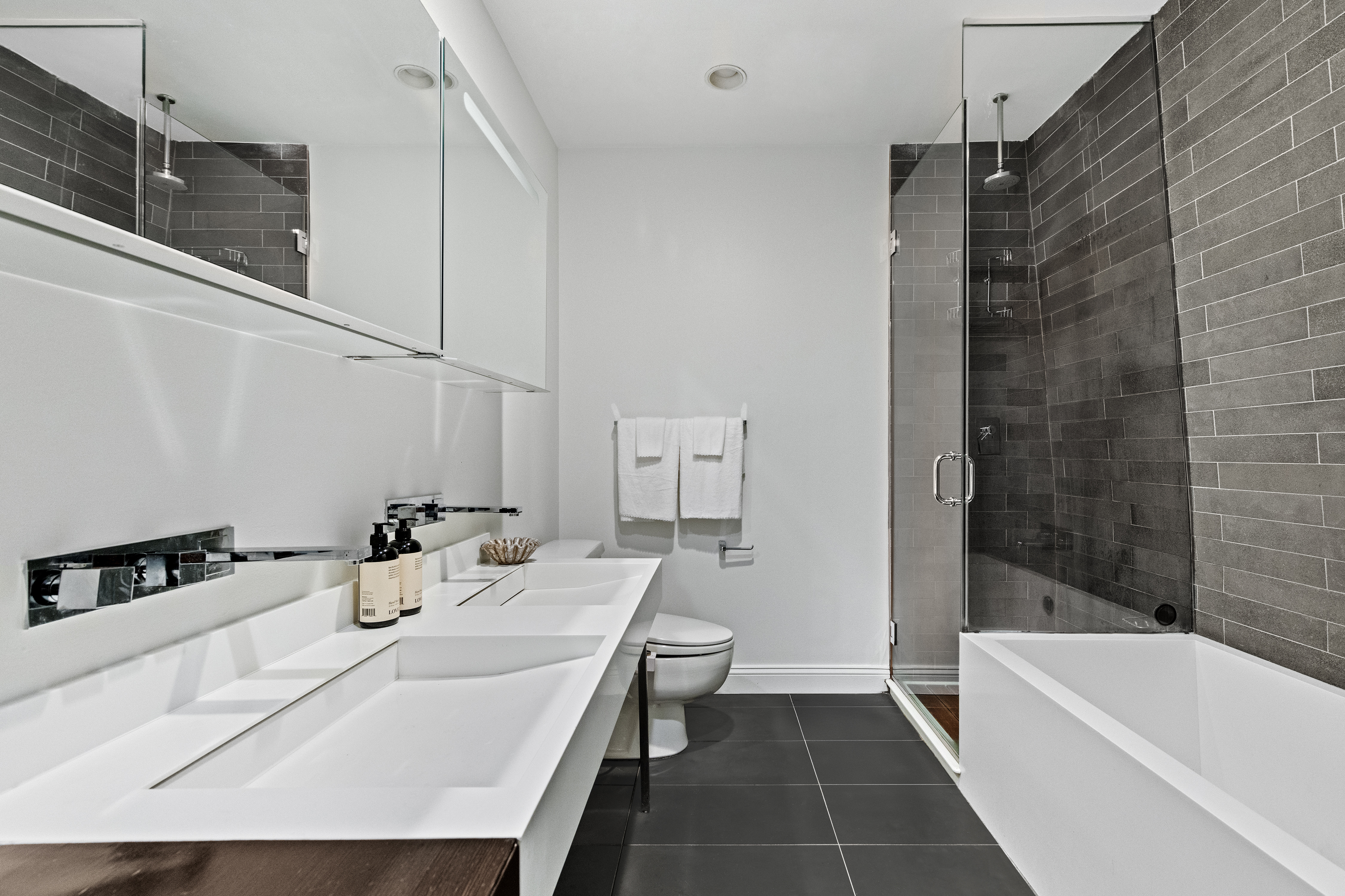 245 10th Avenue, Unit 2W Manhattan, NY 10001 - Photo 13 of 16 a bathroom with a sink a toilet and shower