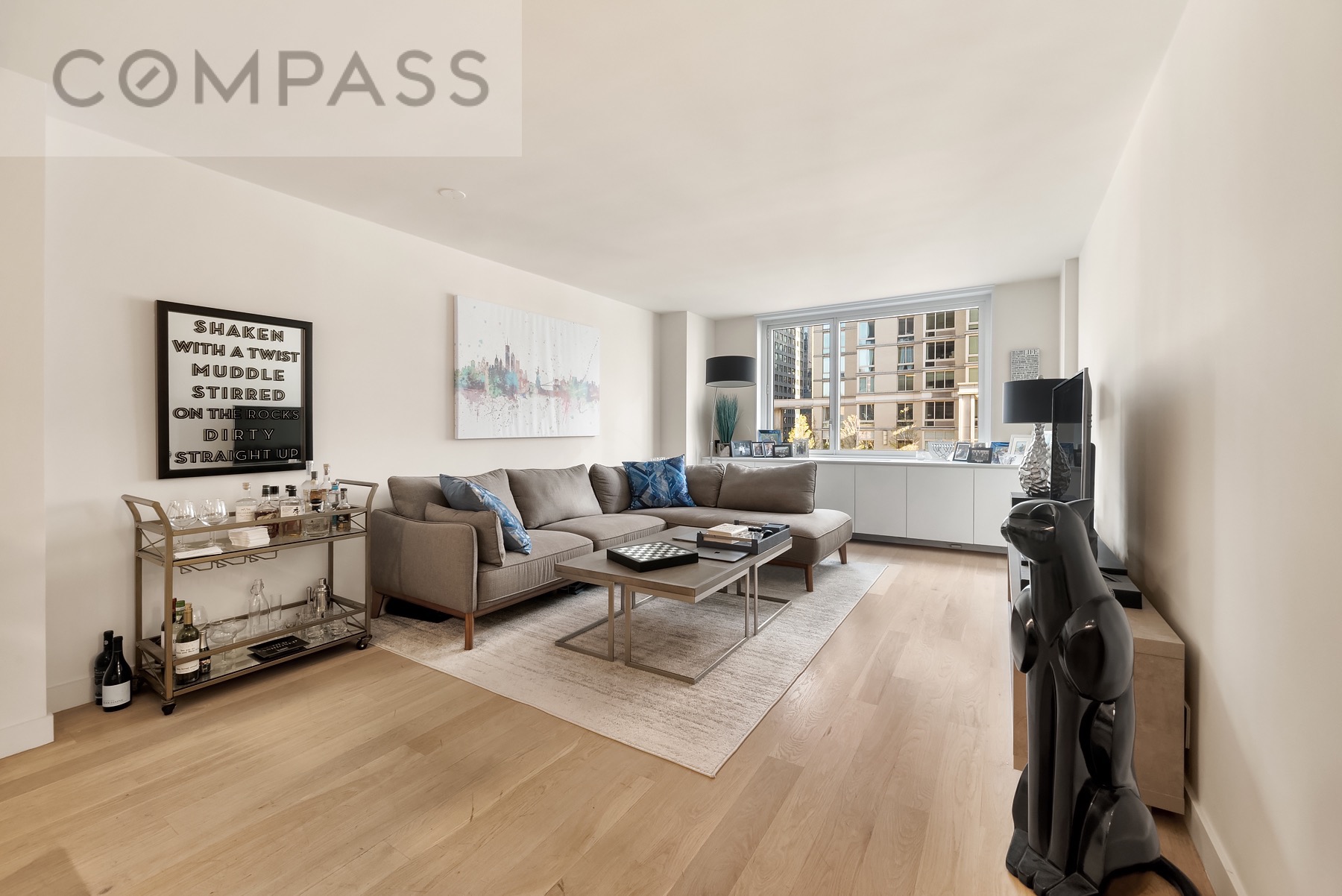 301 West 53rd Street, Unit 7H Manhattan, NY 10019 - Photo 1 of 11 a living room with furniture a flat screen tv and a window