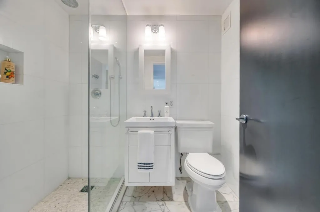 a bathroom with a toilet a sink and mirror