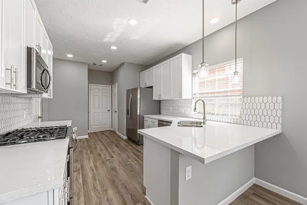 a kitchen with a sink a stove a refrigerator and cabinets