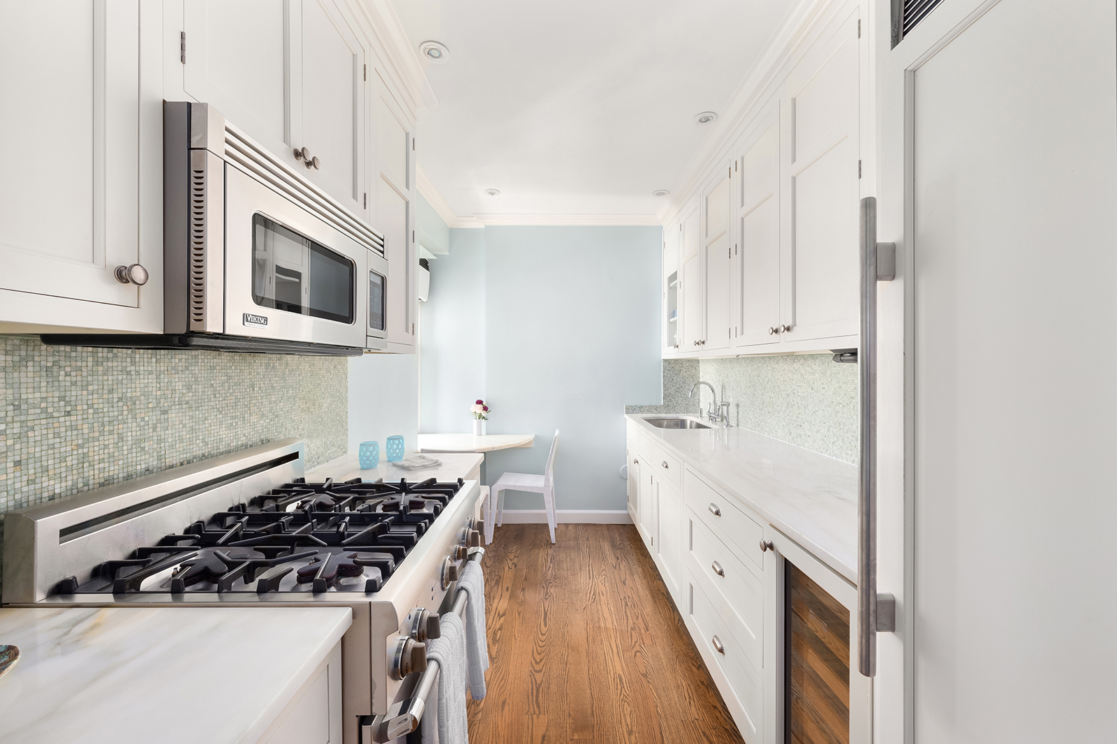 75 Bank Street, Unit 2H Manhattan, NY 10014 - Photo 7 of 18 a kitchen with white cabinets and appliances