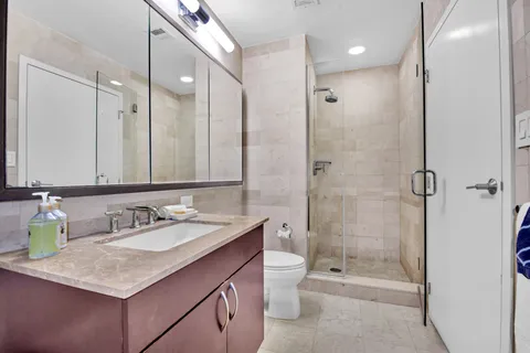 a bathroom with a sink double vanity granite toilet and shower
