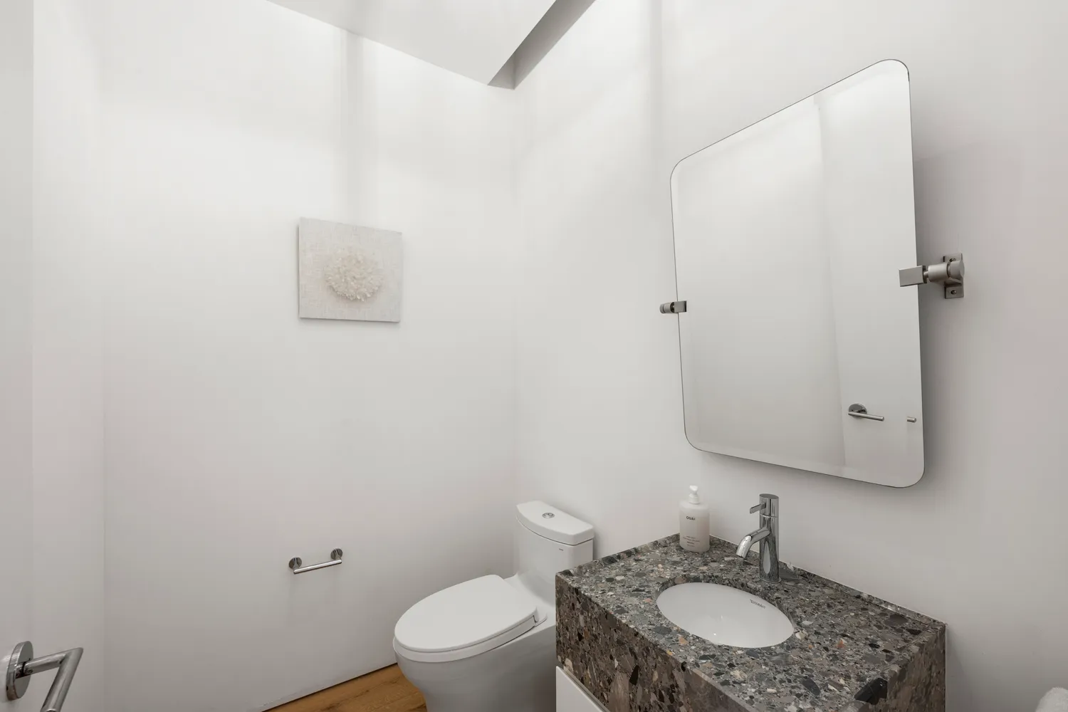 a bathroom with a granite countertop toilet sink and mirror