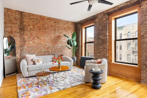 a living room with furniture windows and wooden floor