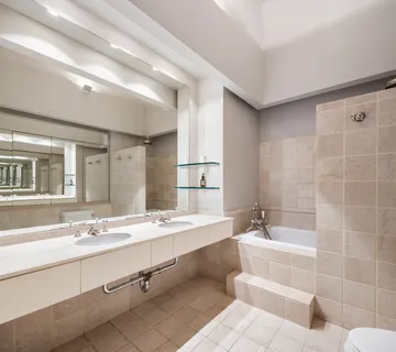 a bathroom with a double vanity sink large mirror and a bathtub