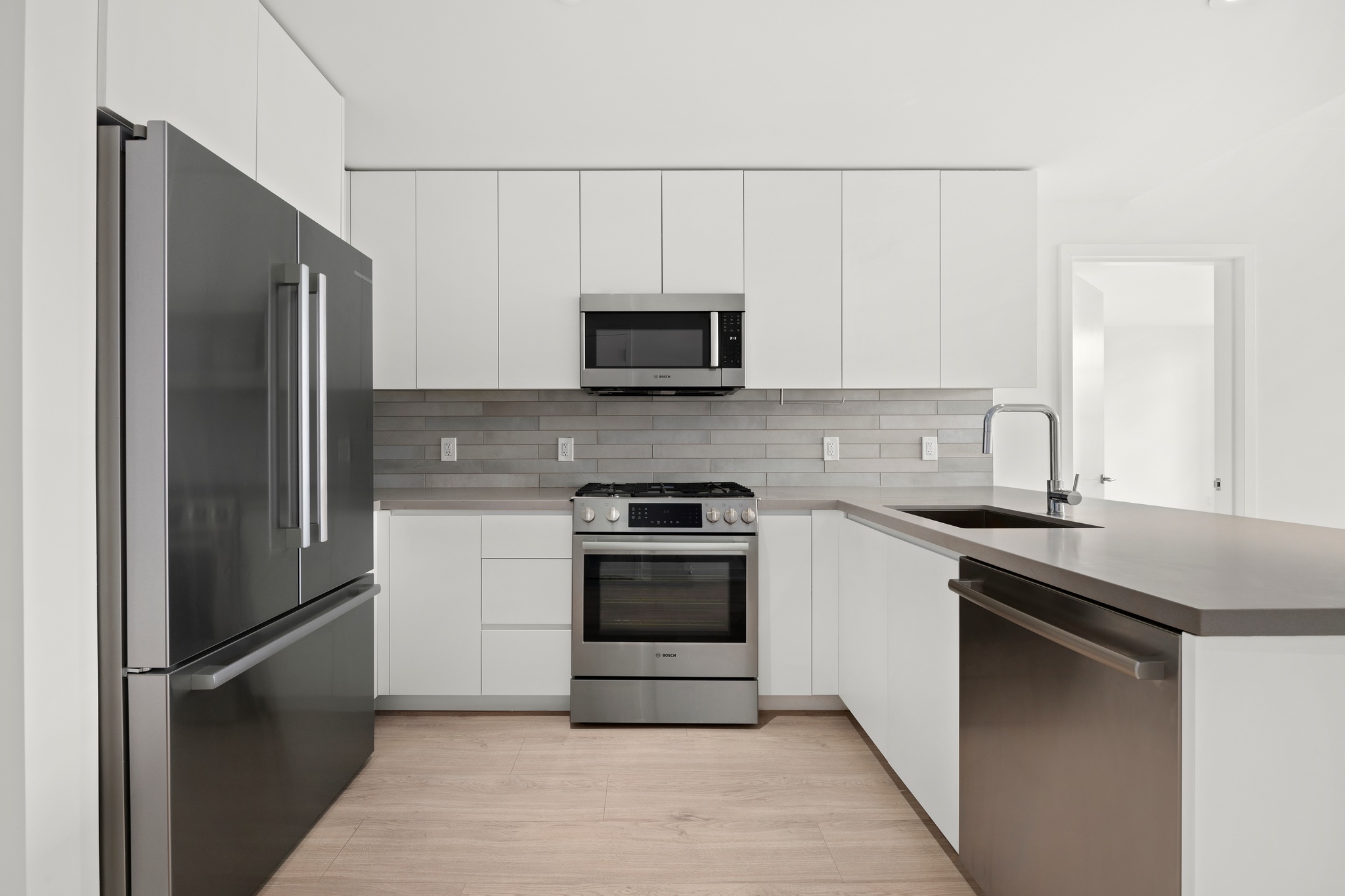 160 Front Street, Unit 706 Brooklyn, NY 11201 - Photo 5 of 17 a kitchen with granite countertop a stove and a refrigerator