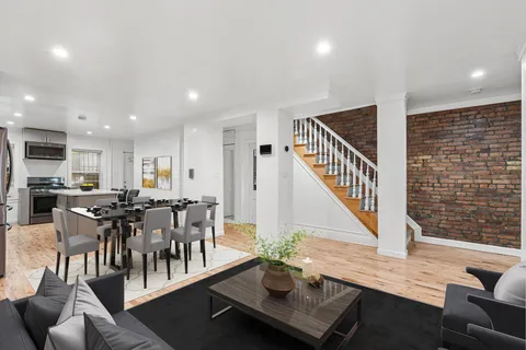 a living room with furniture kitchen view and a large window