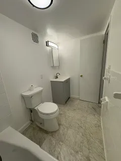 a bathroom with a toilet sink and mirror