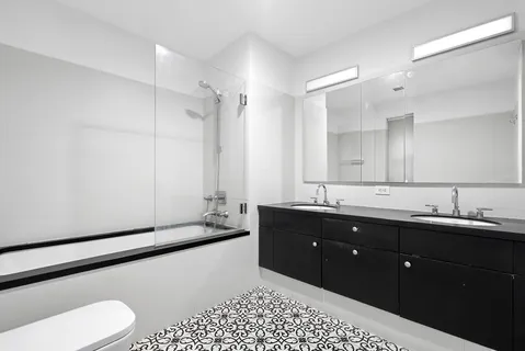 a spacious bathroom with a double vanity sink and mirror