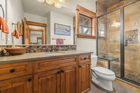 a bathroom with a granite countertop sink mirror vanity and toilet