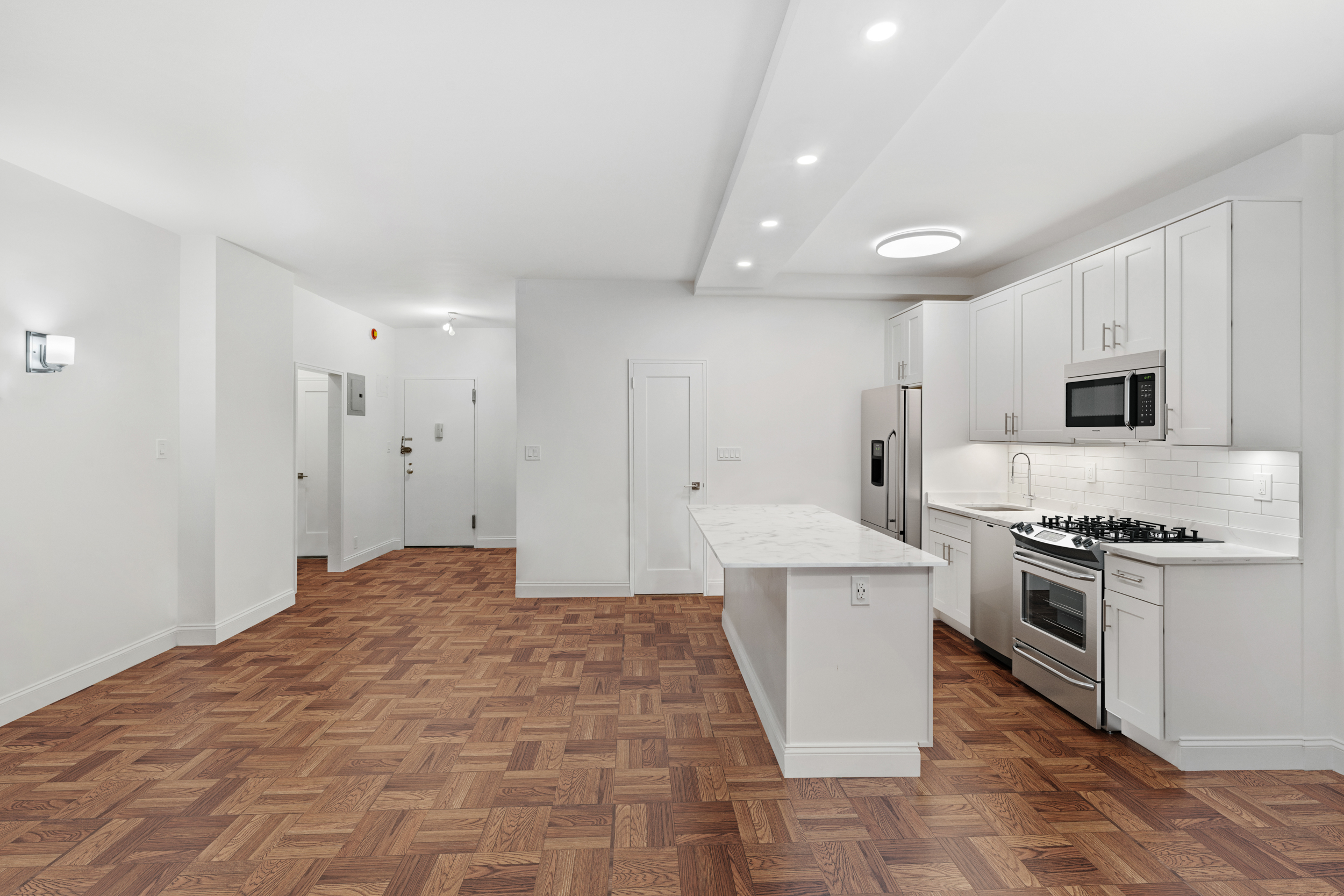 315 East 65th Street, Unit 1A Manhattan, NY 10065 - Photo 4 of 12 a large white kitchen with a stove a sink dishwasher and a refrigerator