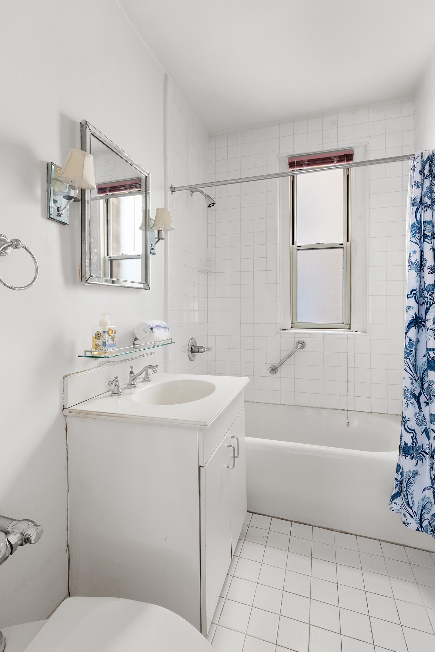 125 East 63rd Street, Unit 2B Manhattan, NY 10065 - Photo 7 of 12 a bathroom with a sink toilet vanity and tub