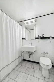 a bathroom with a sink a toilet and a mirror