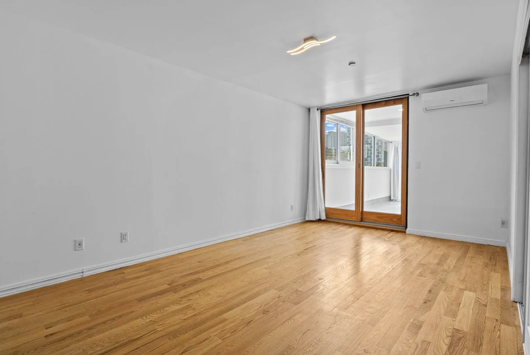2882 West 15th Street, Unit 2B Brooklyn, NY 11224 - Photo 3 of 13 a view of an empty room with wooden floor and a window