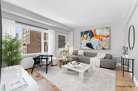 a living room with furniture a bookshelf and a painting on the wall