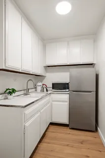 a kitchen with a sink cabinets and wooden floor
