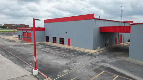 a building with trees next to a road