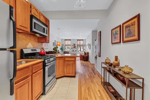 a kitchen with stainless steel appliances granite countertop a stove top oven a sink dishwasher and cabinets with wooden floor