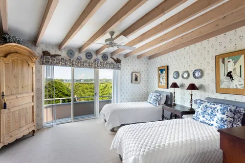 a bedroom with large windows and large bed