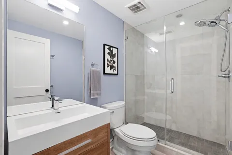 a bathroom with a sink a toilet and shower