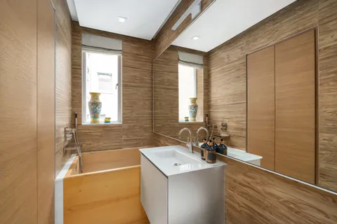 a bathroom with a tub sink and mirror