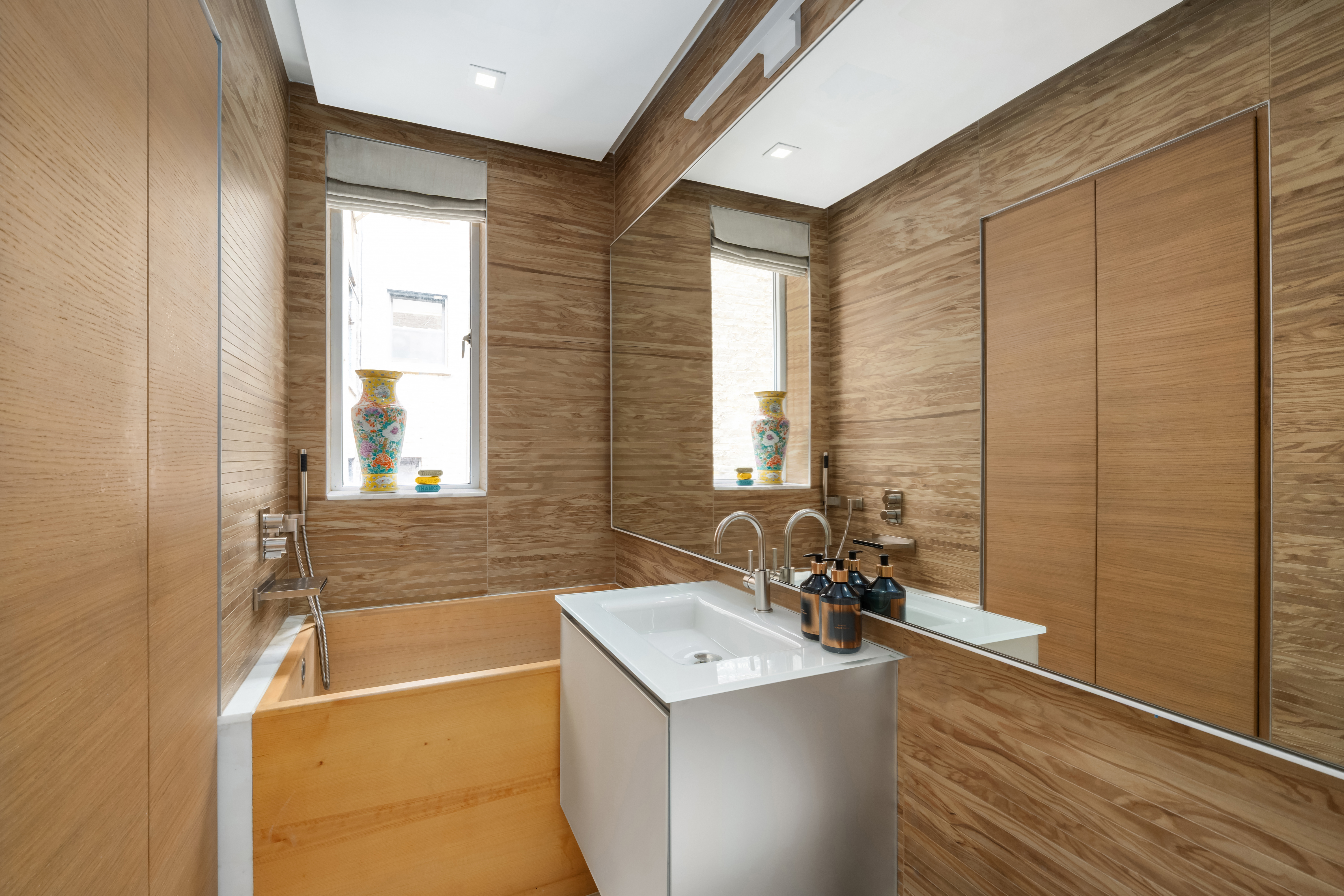 455 East 51st Street, Unit 2F Manhattan, NY 10022 - Photo 11 of 17 a bathroom with a tub sink and mirror