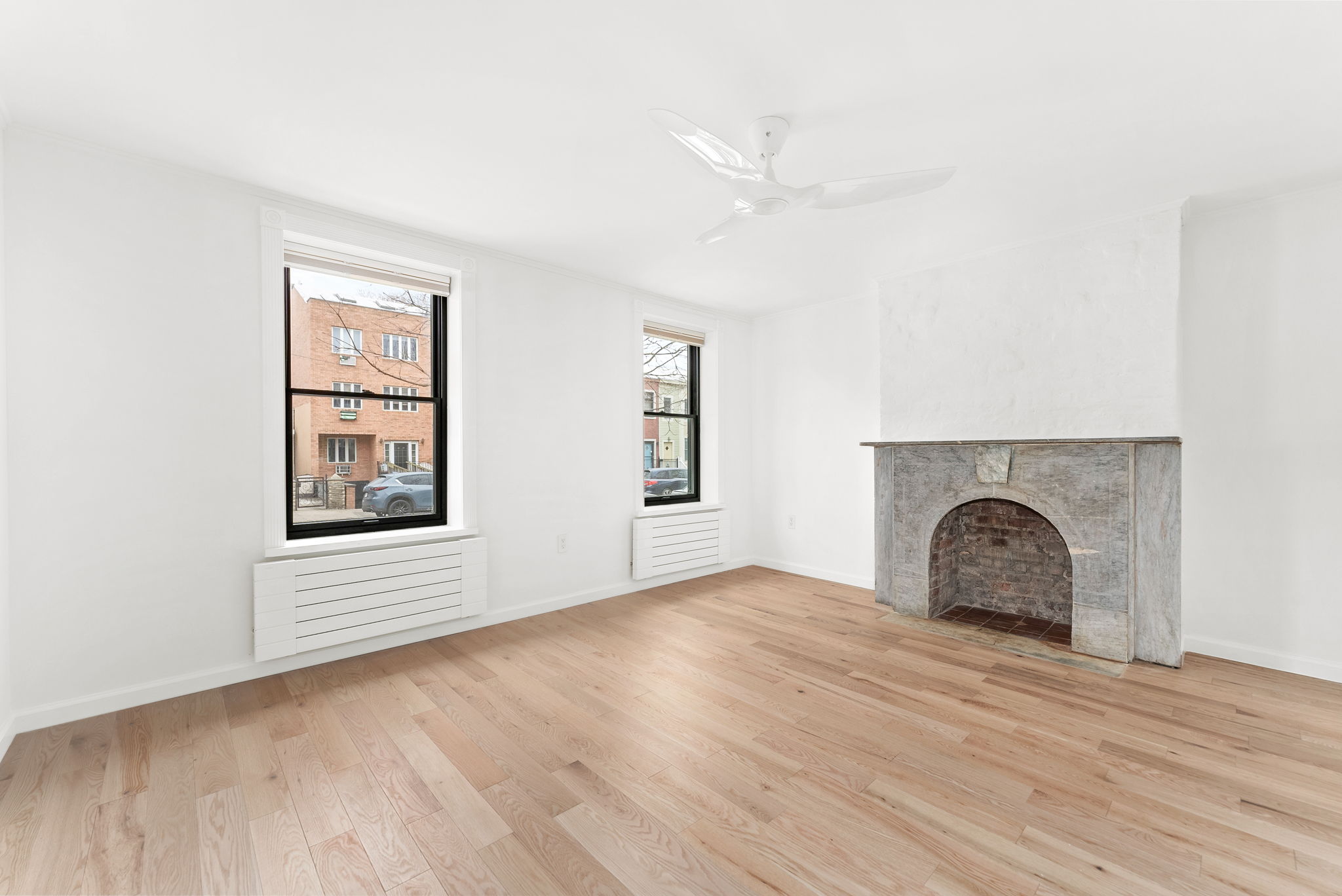 54 East 4th Street, Unit 1 Brooklyn, NY 11218 - Photo 5 of 12 an empty room with windows and fireplace