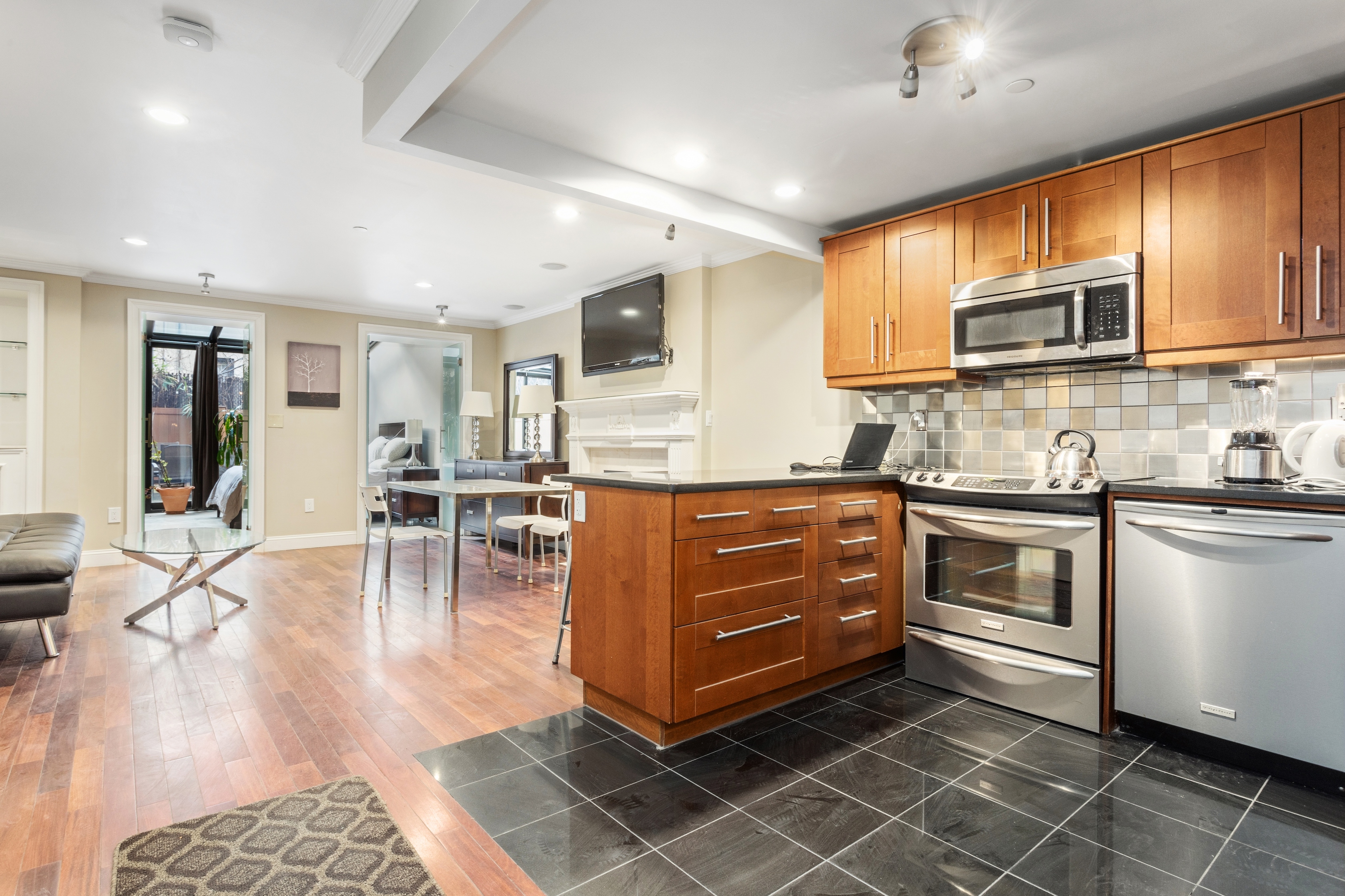 258 West 71st Street, Unit BR Manhattan, NY 10023 - Photo 6 of 13 a kitchen with stainless steel appliances kitchen island granite countertop a stove and cabinets