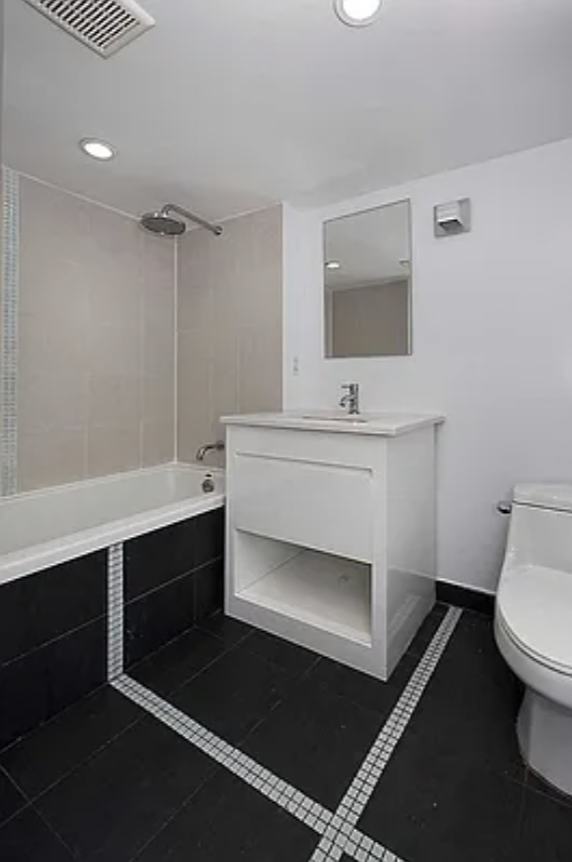 105 Grand Avenue, Unit 1F Brooklyn, NY 11205 - Photo 3 of 7 a bathroom with a sink toilet a mirror and shower