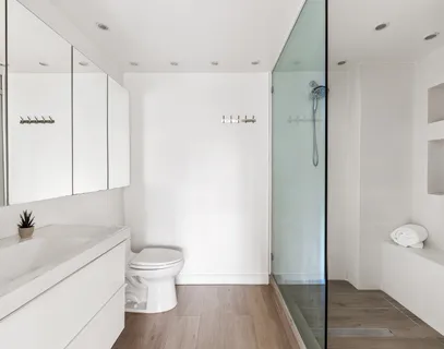 a bathroom with a sink a toilet and shower