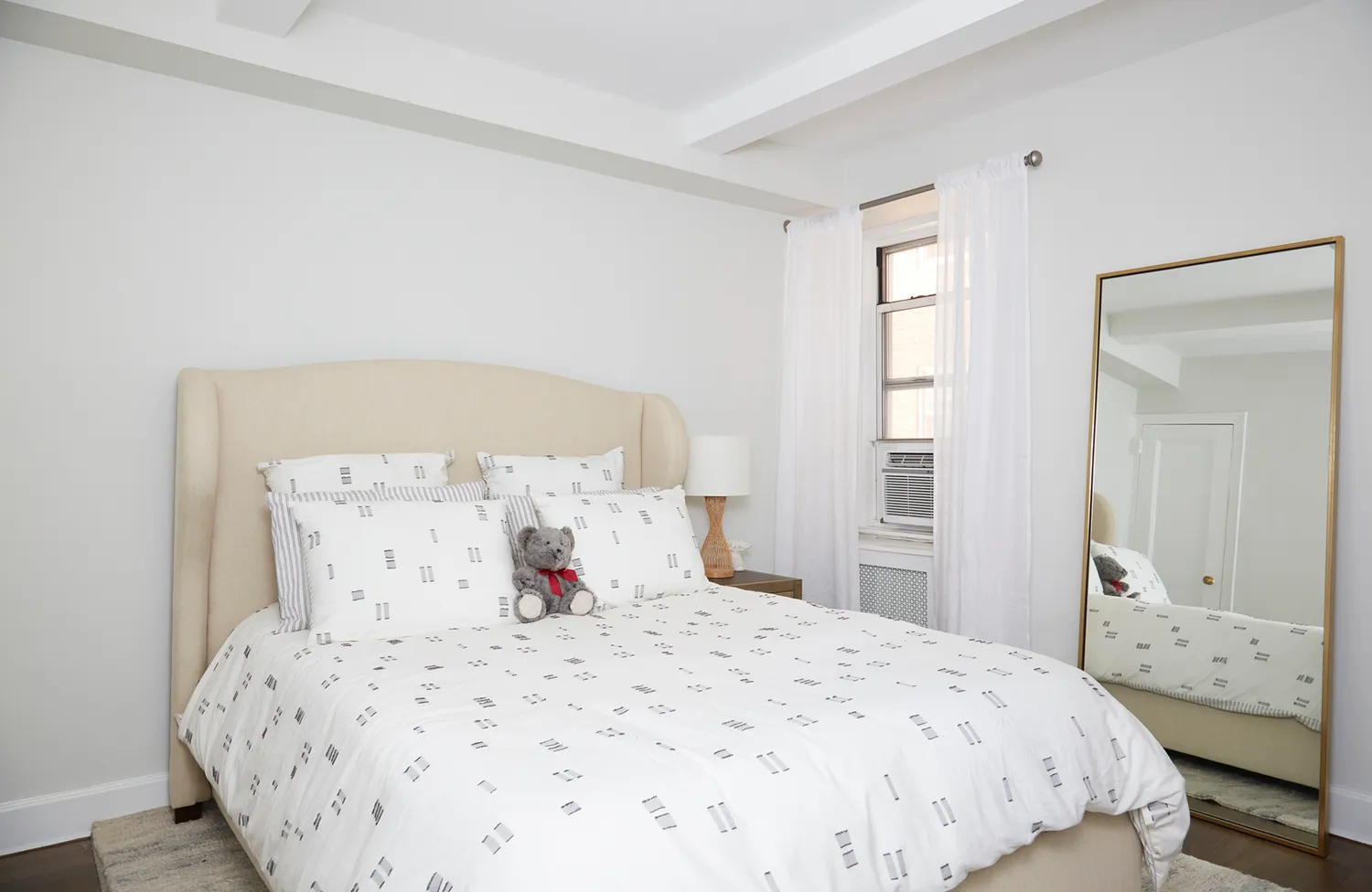 a bedroom with a bed and a large mirror