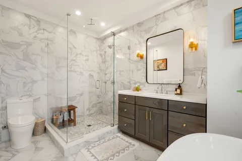 a bathroom with a double vanity sink toilet mirror and shower