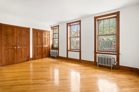 a view of an empty room with window and bathroom