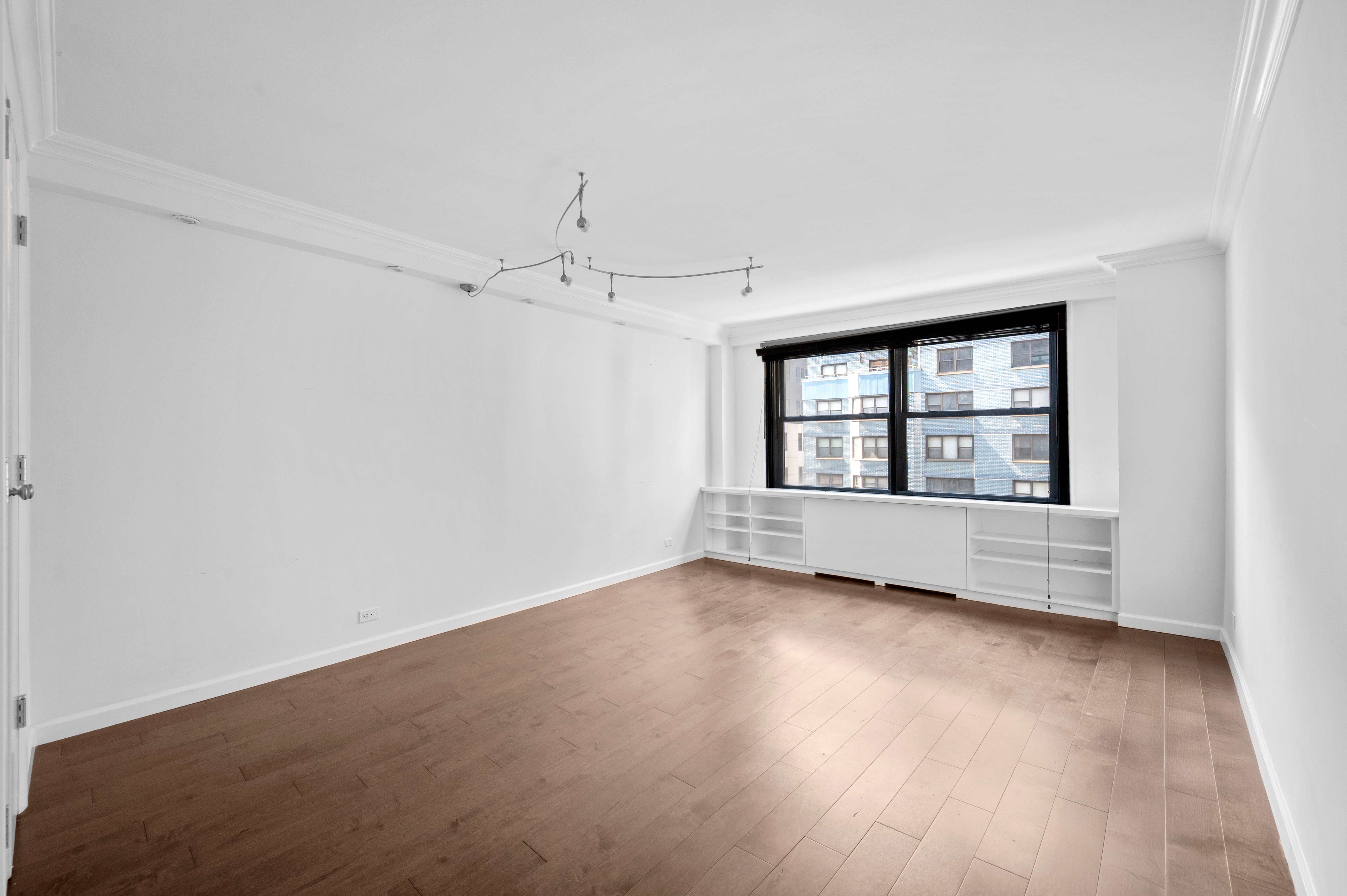 225 East 57th Street, Unit 14F Manhattan, NY 10022 - Photo 10 of 14 an empty room with wooden floor and windows